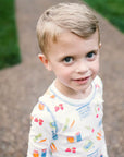 Little Boy Wearing Heyward House Farmer's Market Pajama Set Outside with Details