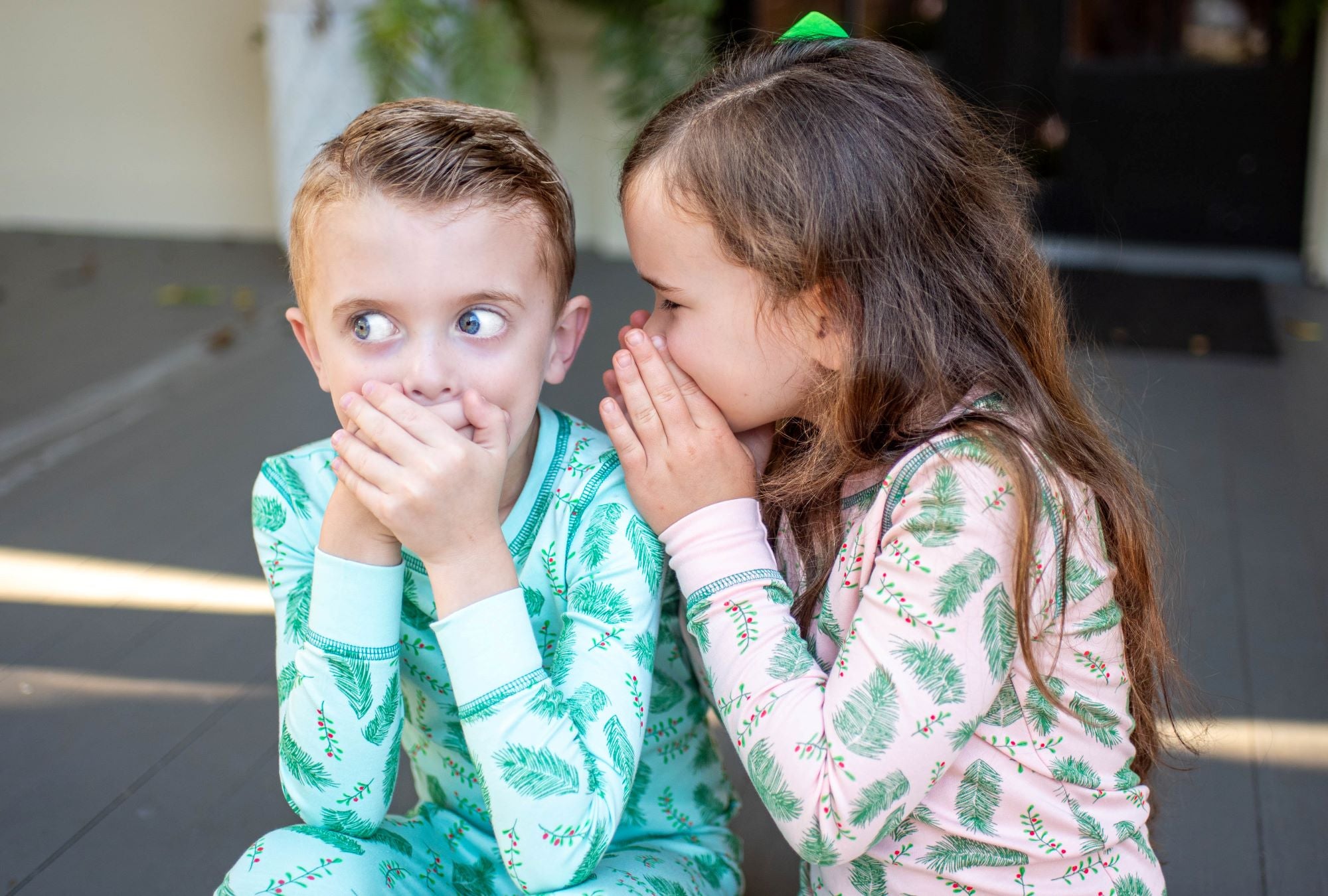 Children wearing two-piece pajama set with vintage Christmas holly pattern made with pima cotton