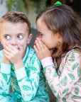 Children wearing two-piece pajama set with vintage Christmas holly pattern made with pima cotton