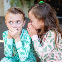 Children wearing two-piece pajama set with vintage Christmas holly pattern made with pima cotton