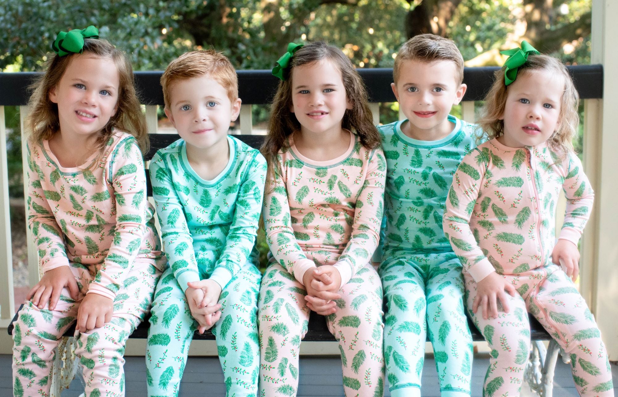 Children wearing Blue and Pink two-piece pajama set with vintage Christmas holly pattern made with pima cotton