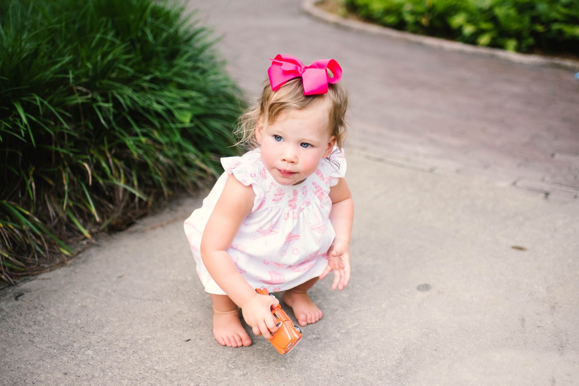 Little girl in Pink Pram Heyward House Smocked Dress