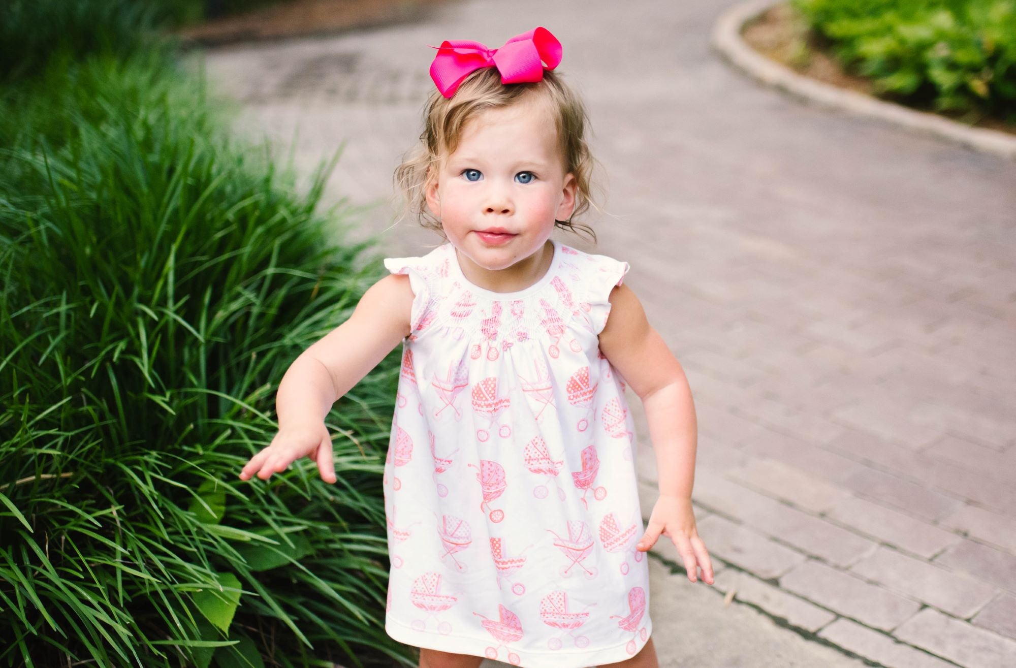 Little girl in Pink Pram Heyward House Smocked Dress