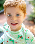 Little Boy wearing Mint green two-piece pajama set with vintage Christmas reindeer pattern made with pima cotton