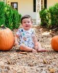 Boy in Heyward House Halloween Costumes Short Sleeve Romper surrounded by big pumpkins