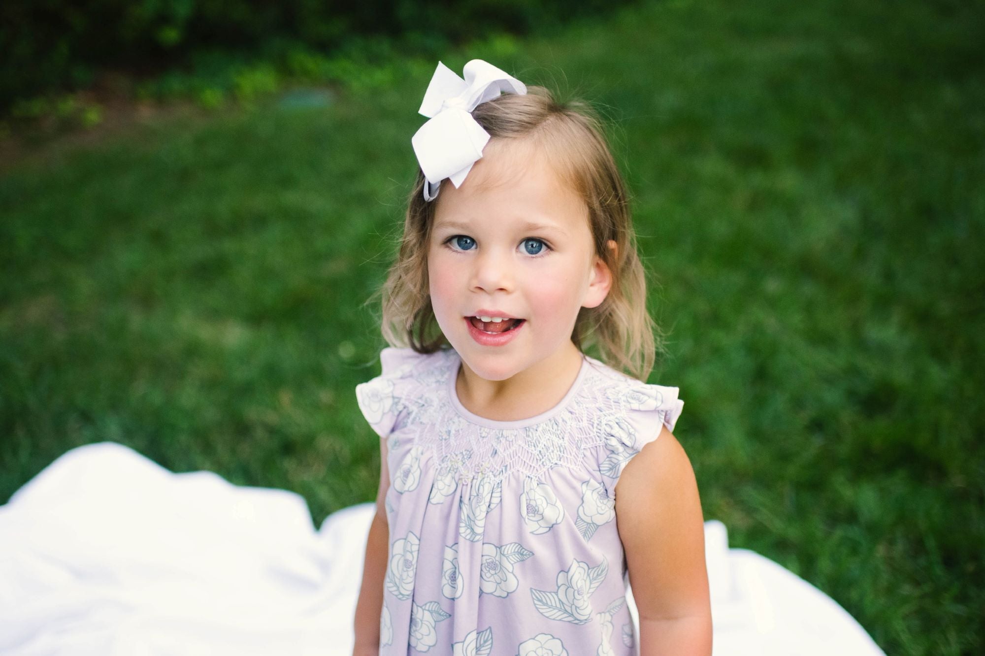 Little Girl playing in Heyward House Camellia Smocked Dress