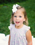 Little Girl playing in Heyward House Camellia Smocked Dress