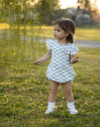 Little girl in field wearing dragonflies bubble in white and green