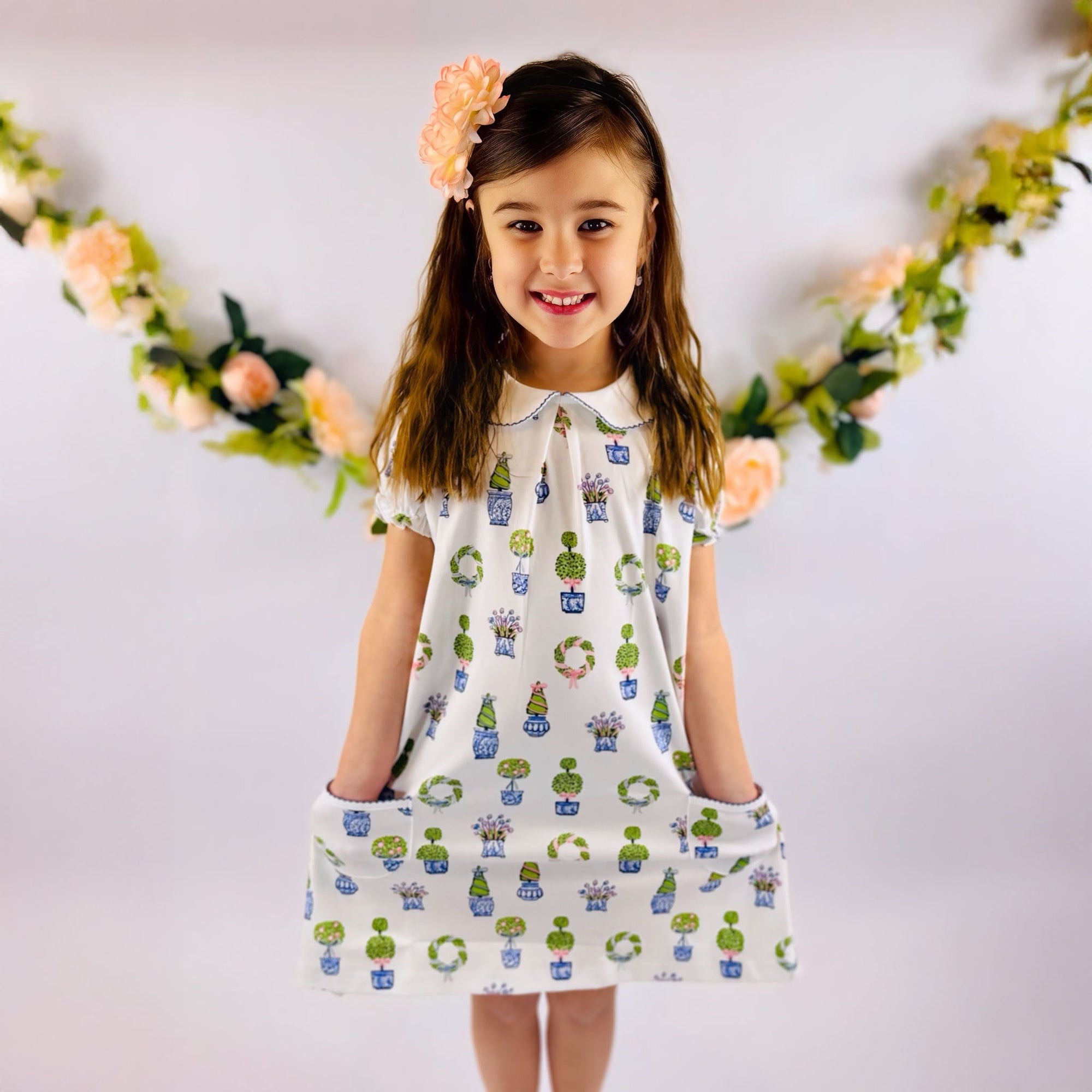 Young girl in floral printed topiary dress for spring.