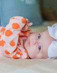 baby-girl-with-blue-eyes-wearing-heyward-house-gown-laying-on-bed