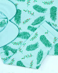 Close-up of blue boys playsuit with classic peter-pan collar and vintage Christmas holly pattern made in pima cotton