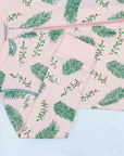 Detail of zipper area of light pink footed pajama with vintage-inspired Christmas holly pattern made in pima cotton