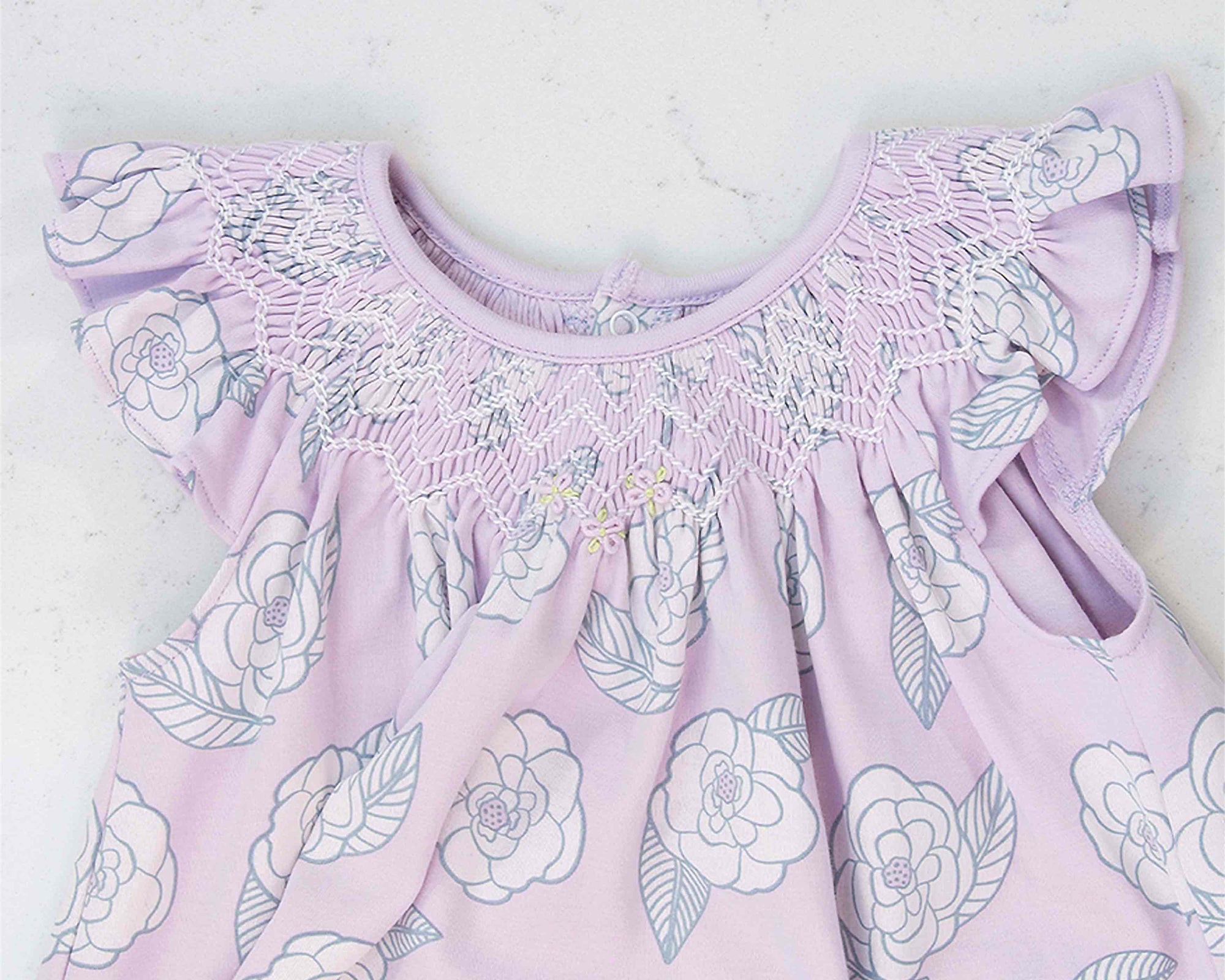 detailed view pink girls dress with smock and camellia flower pattern made in pima cotton