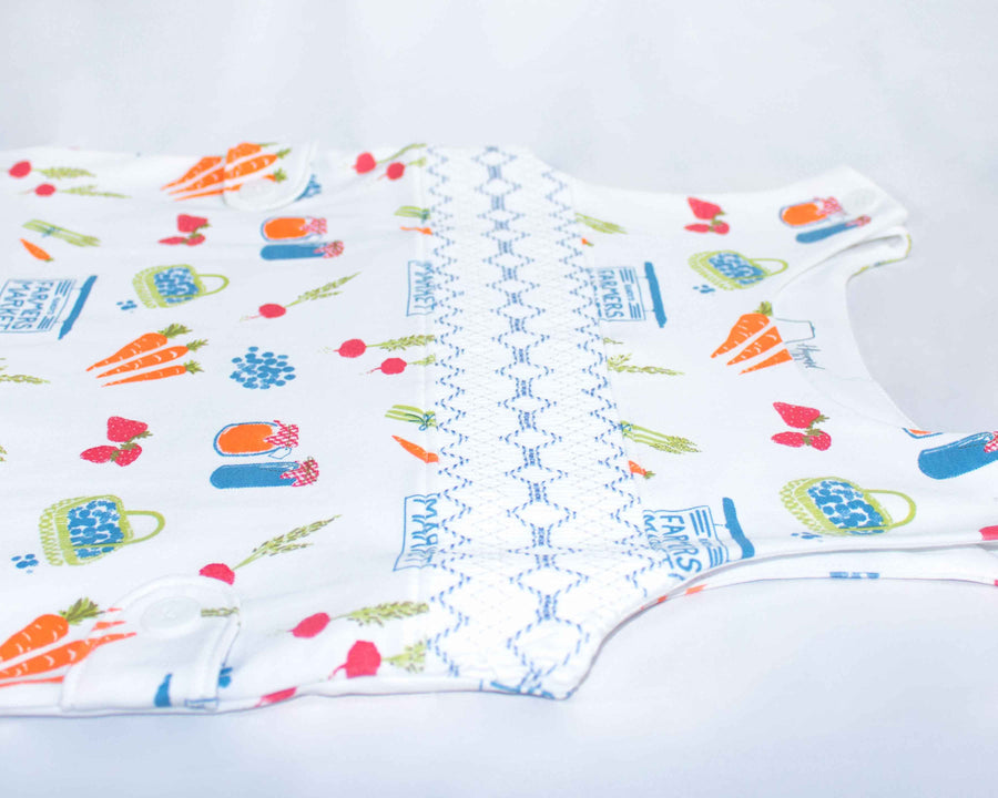 Close up of white Jon Jon with smock with fruit and vegetable pattern pattern