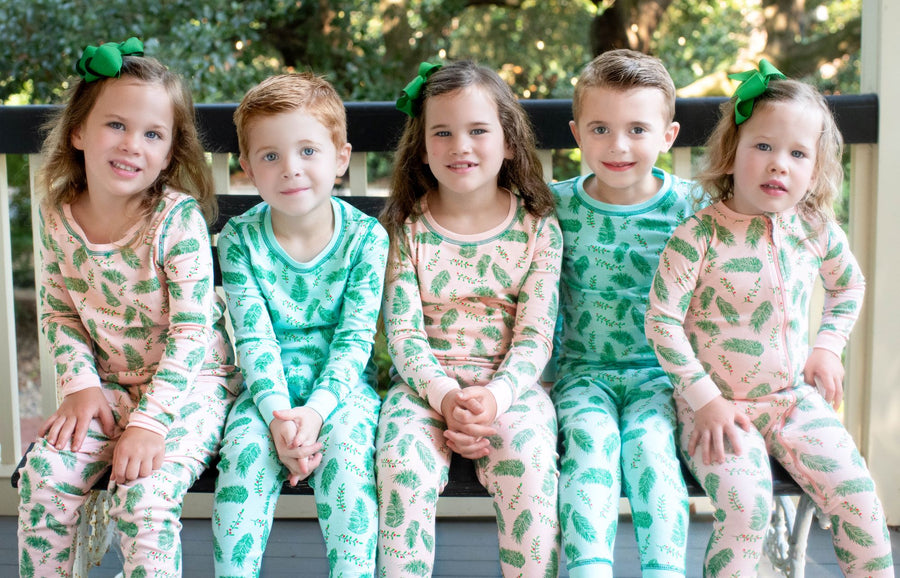 Children wearing Blue and Pink two-piece pajama set with vintage Christmas holly pattern made with pima cotton