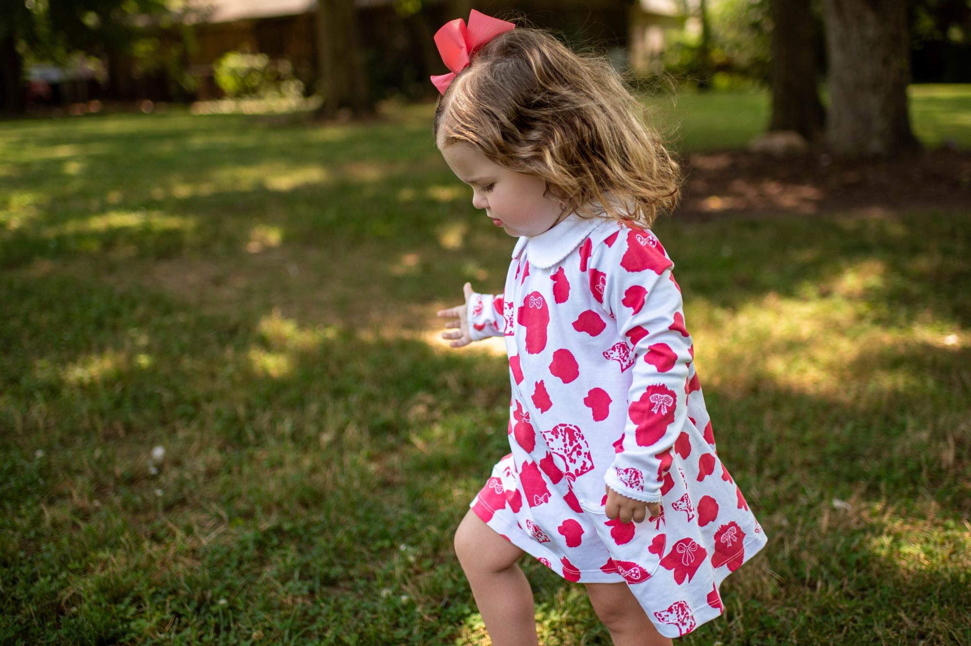 Little Girl Walking in Heyward House Pink Dog Pattern Pocket Twirl Dress