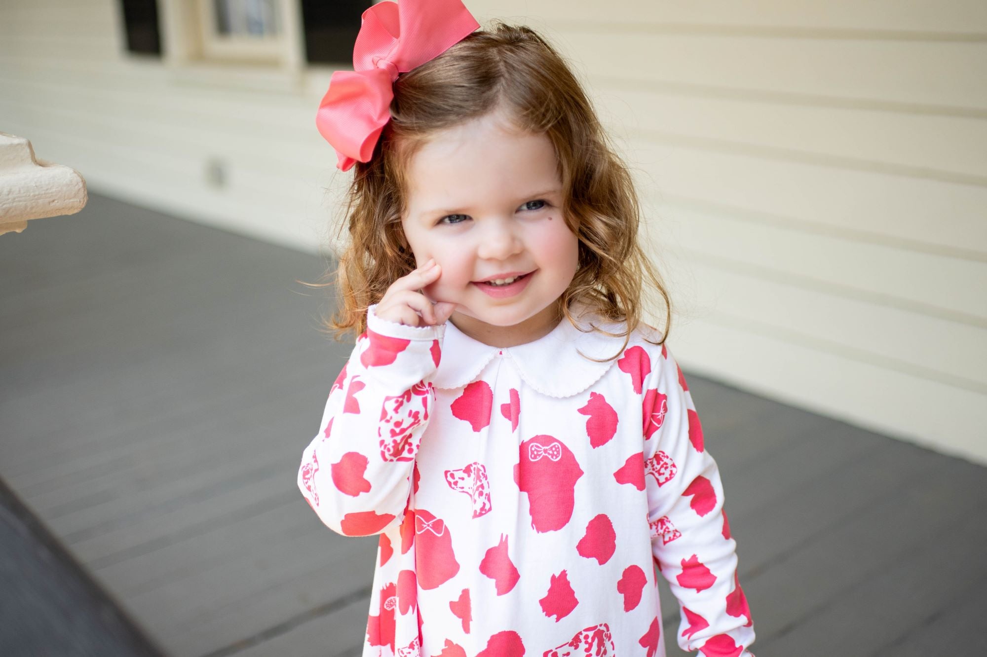Little Girl Smiling in Heyward House Pink Dog Pattern Pocket Twirl Dress