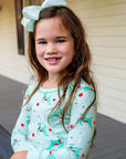Little Girl wearing Mint green two-piece pajama set with vintage Christmas reindeer pattern made with pima cotton