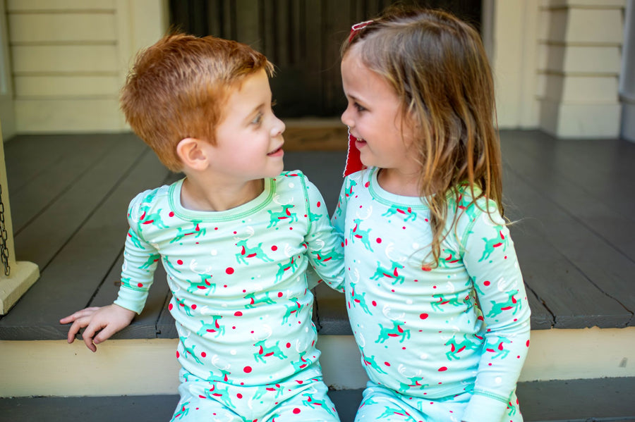 Little Children wearing Mint green two-piece pajama set with vintage Christmas reindeer pattern made with pima cotton