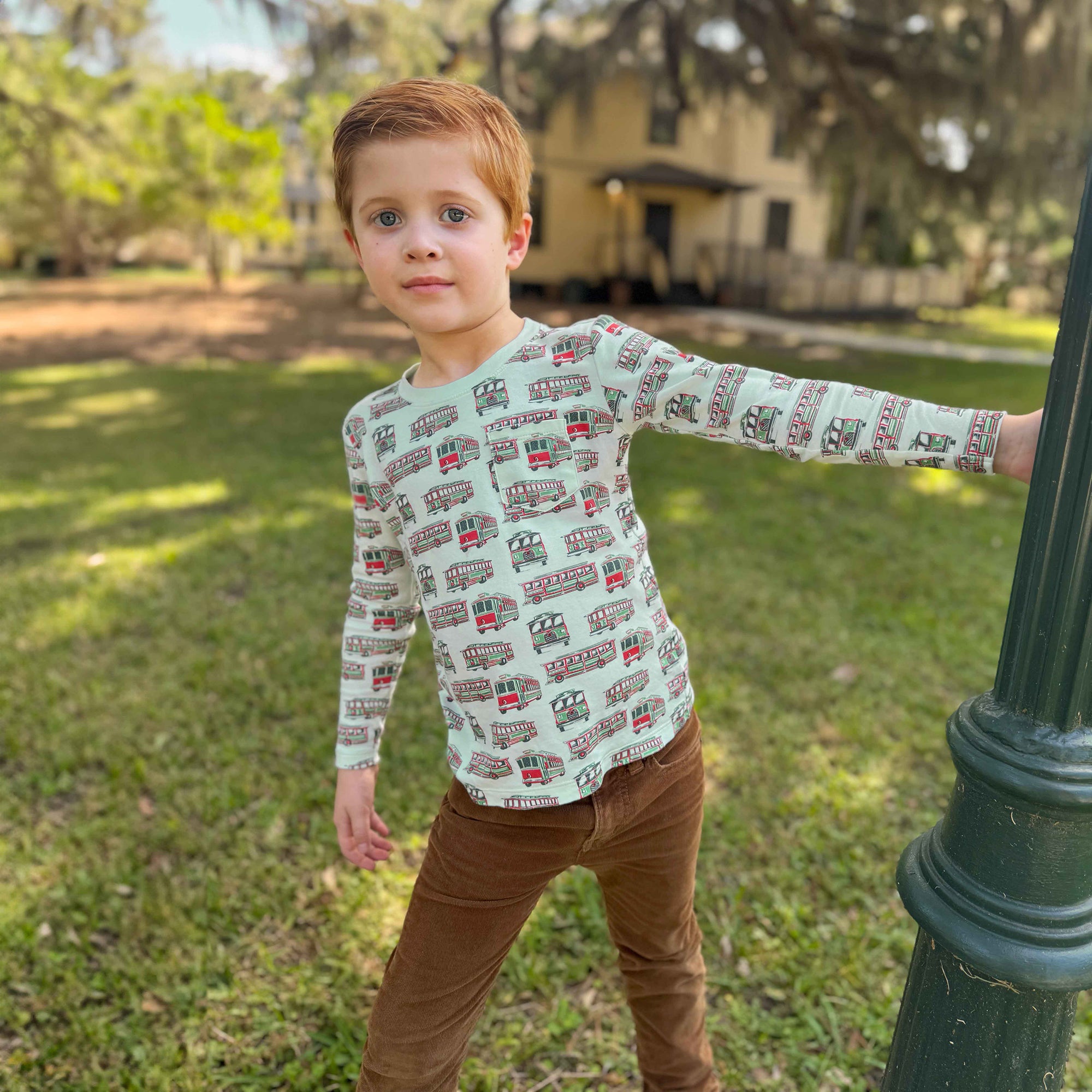 boy leaning away from streetlight in trolley shirt square