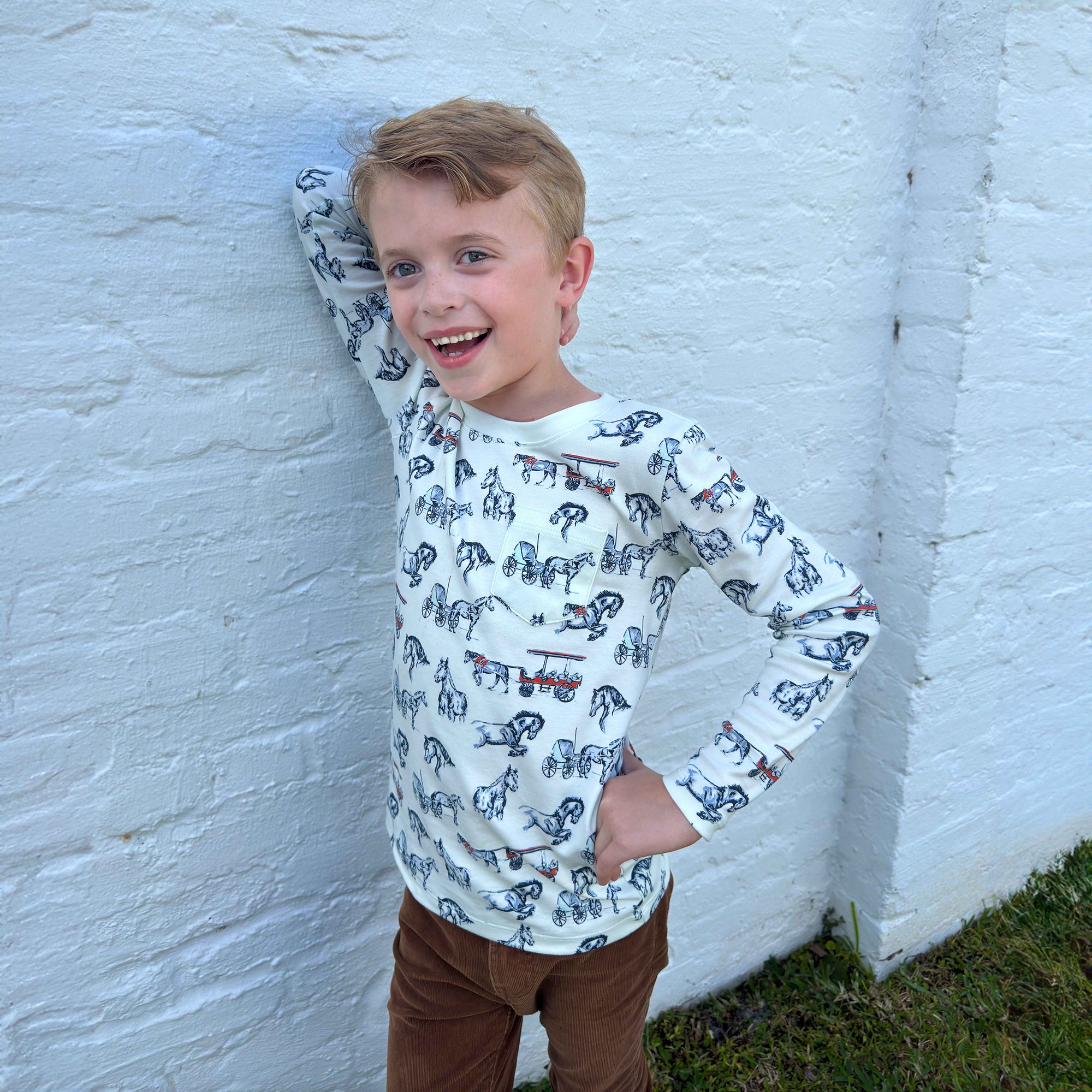 boy leaning on wall in pima horse sketch shirt