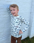 boy leaning on wall in pima horse sketch shirt