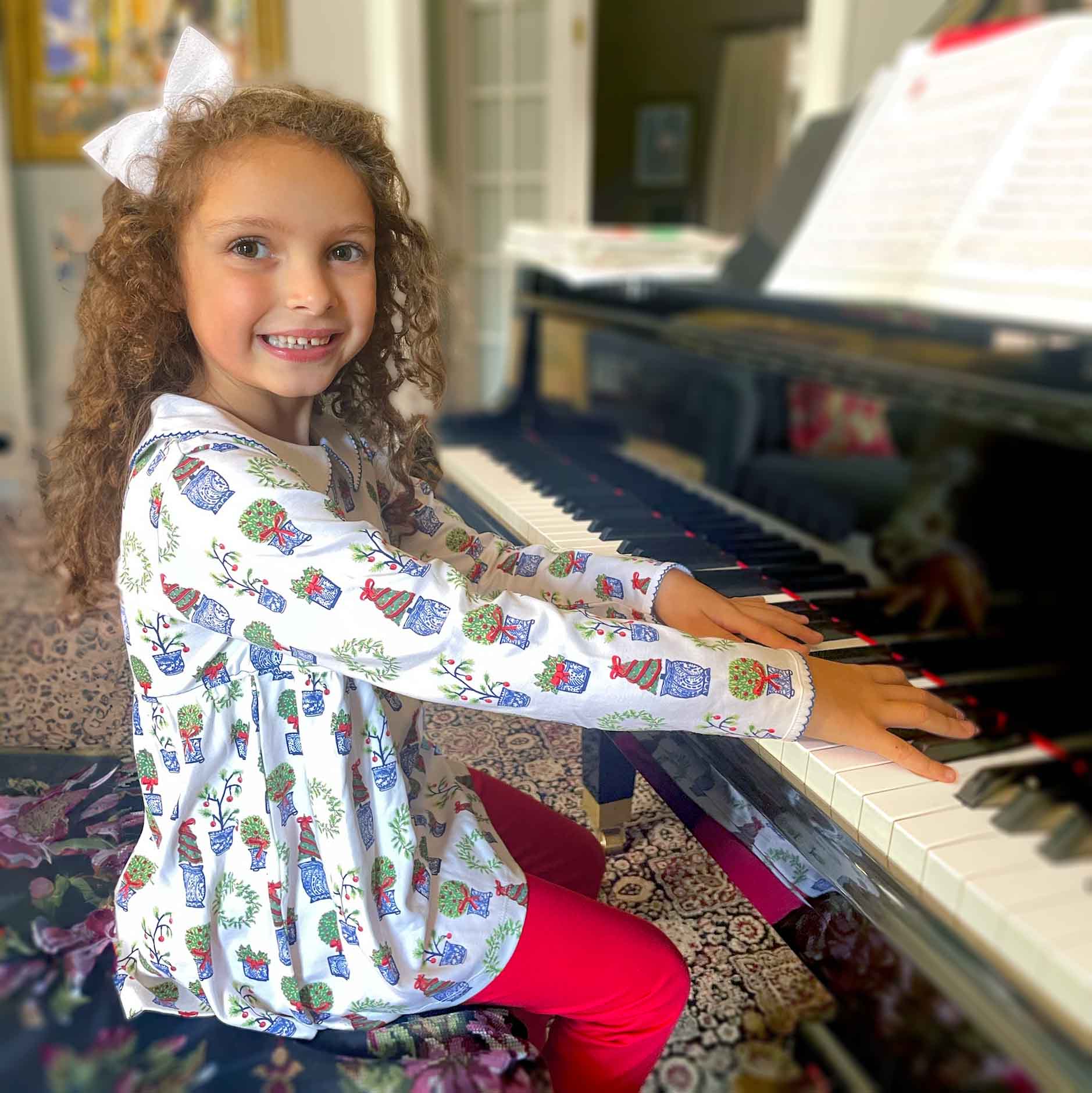 curly haired girl at piano wearing beautiful and elegant shirt dress combo with christmas topiary design