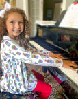 curly haired girl at piano wearing beautiful and elegant shirt dress combo with christmas topiary design