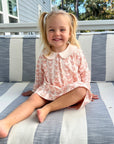 smiling girl wearing pink pima dress with butterfly pattern