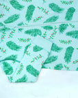 Detail of zipper area of light blue footed pajama with vintage Christmas holly pattern made in pima cotton