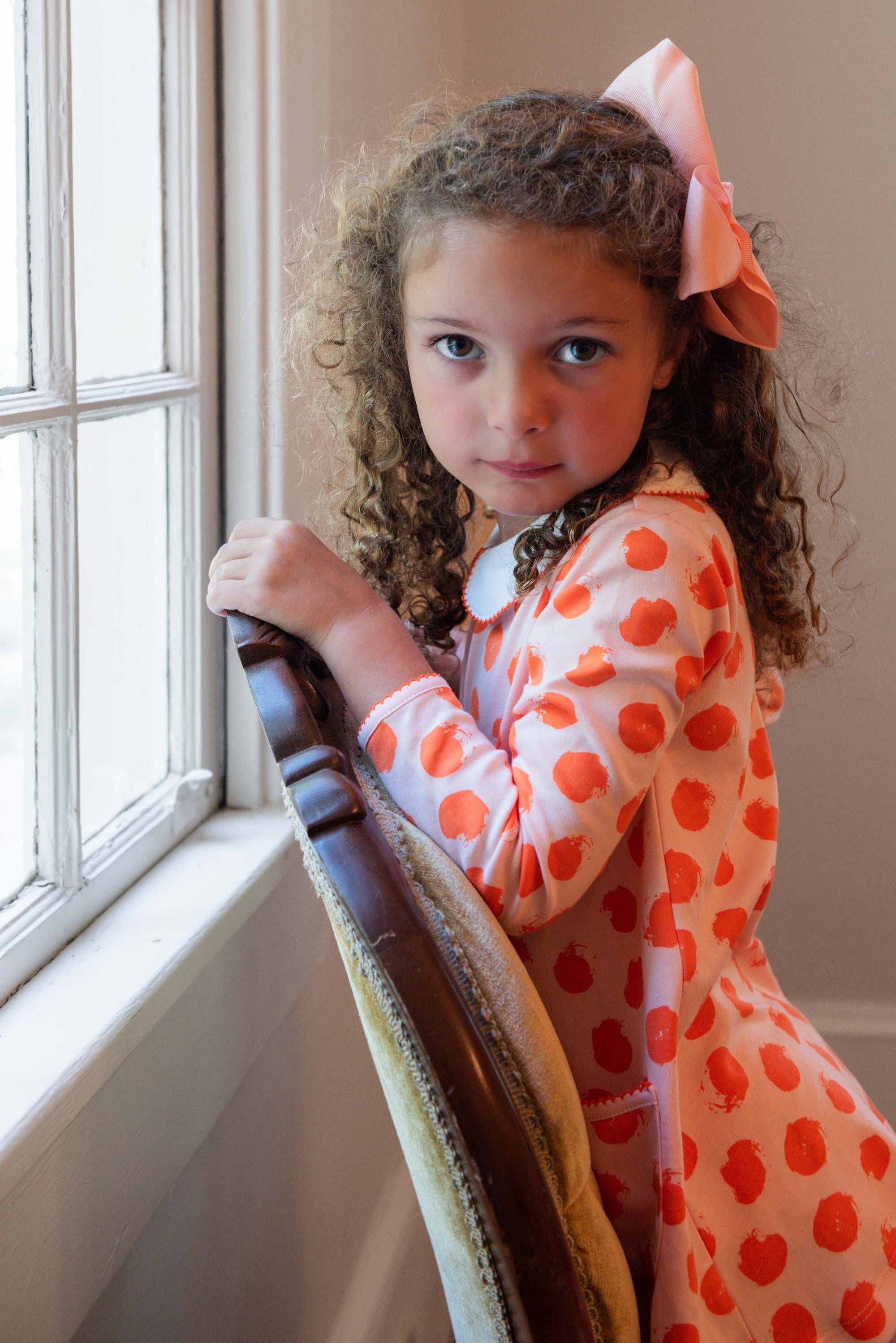 Little Girl with Bow in Heyward House Orange Polka Dot Pocket Twirl Dress