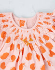 detailed view pink girls dress with smock and orange dots pattern made in pima cotton