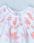 detailed view white girls dress with smock and vintage-inspired baby carriage pattern made in pima cotton