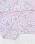 Detail of zipper area of pink footed pajama with camellia flower pattern made in pima cotton