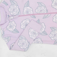 Detail of zipper area of pink footed pajama with camellia flower pattern made in pima cotton